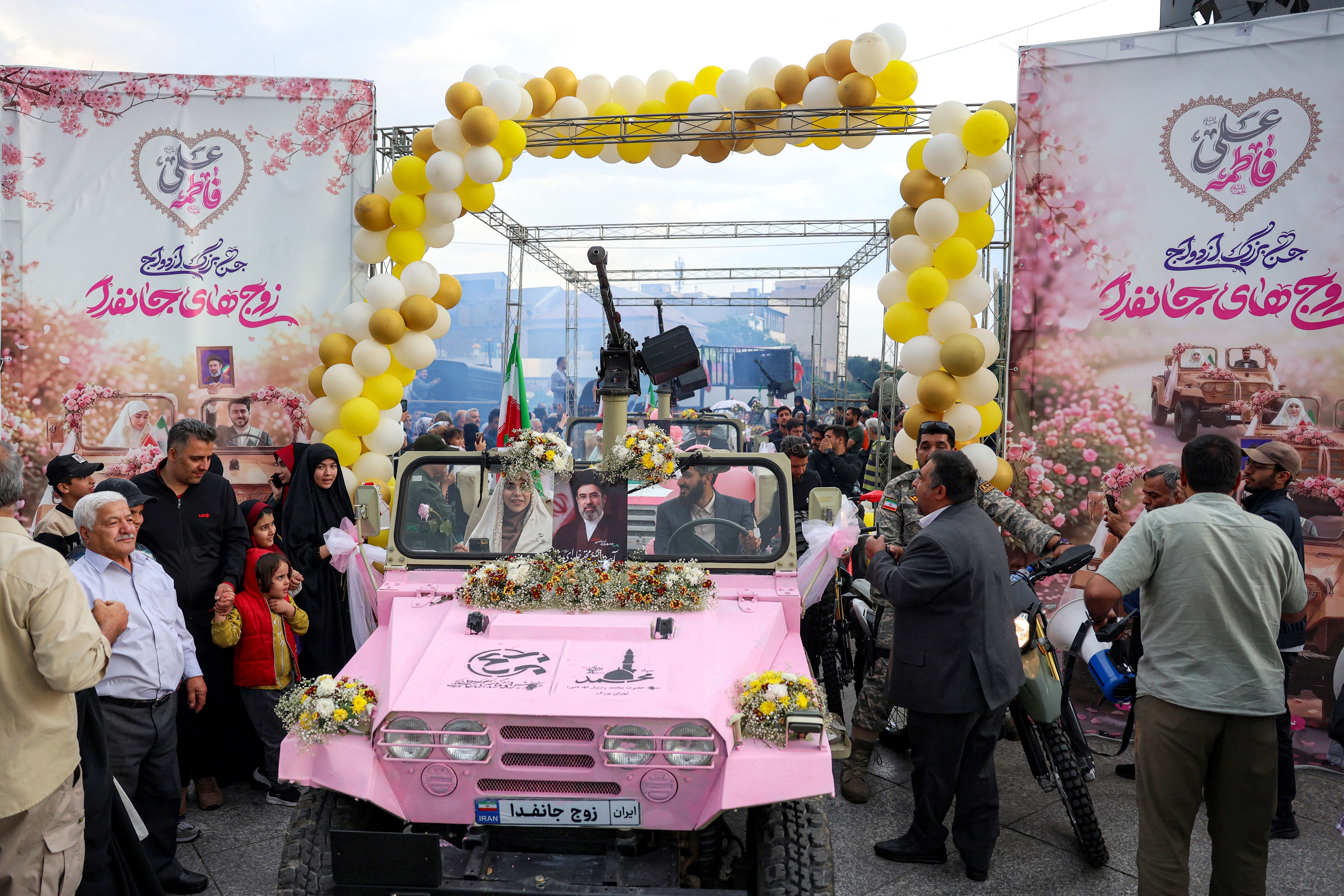 Cosa ci fanno palloncini e missili (rosa) nelle piazze di Teheran, diventate teatro dei matrimoni di massa in tempo di guerra